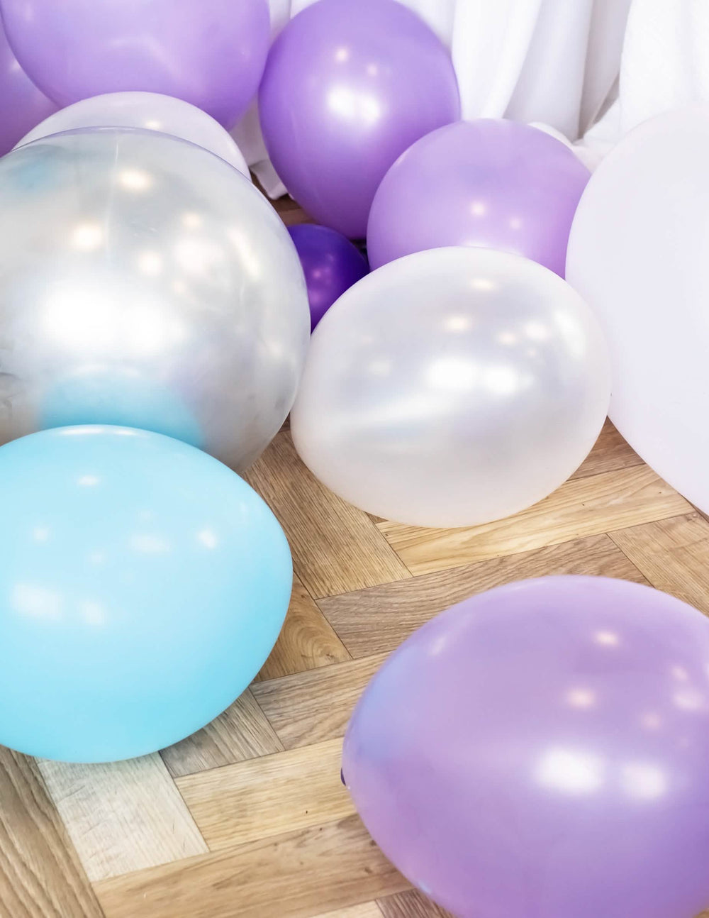 Mise em situação no chão de balões metalizados para festa branco pérola