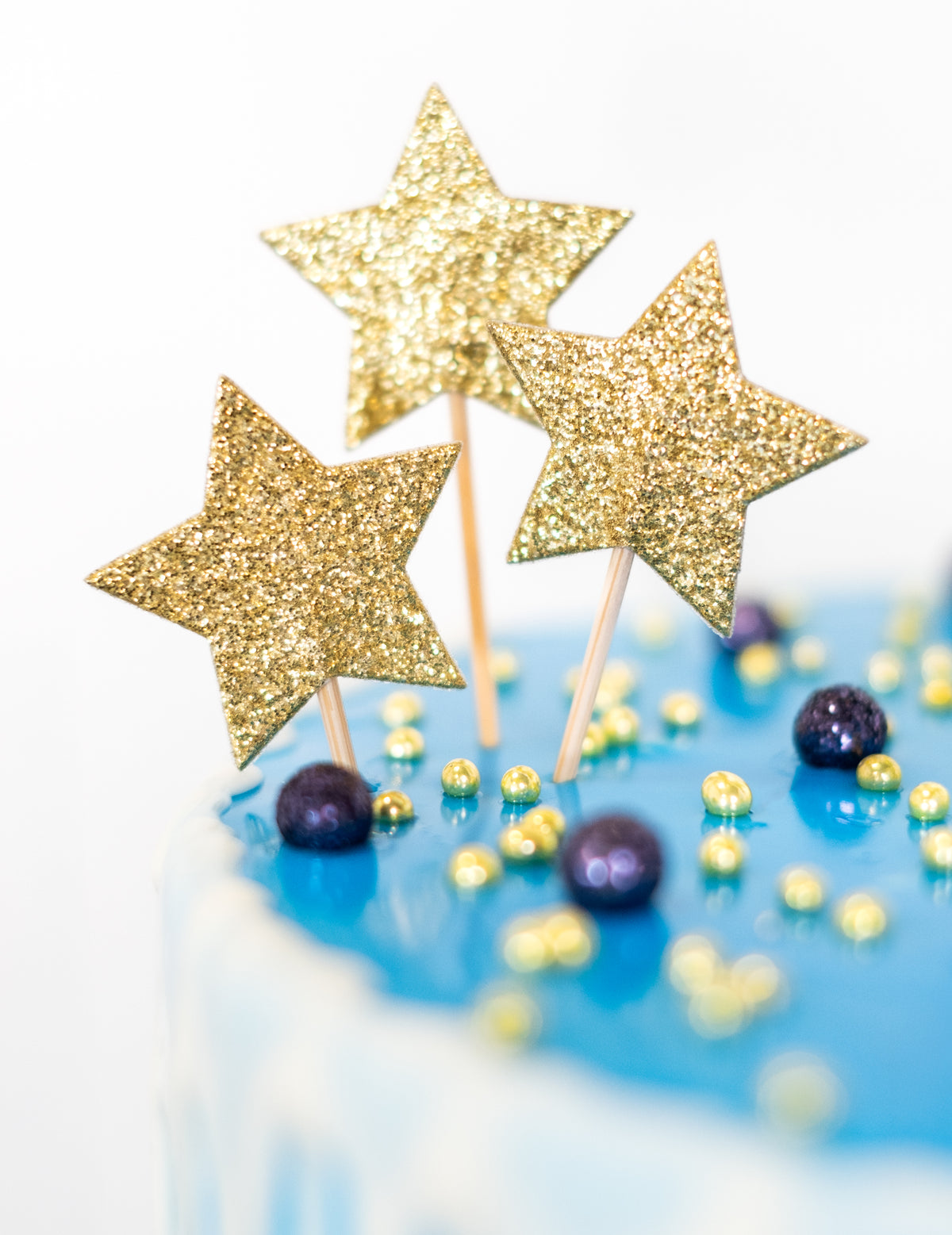 Gros plan sur les paillettes dorées du cake topper sur pic étoile pour anniversaire