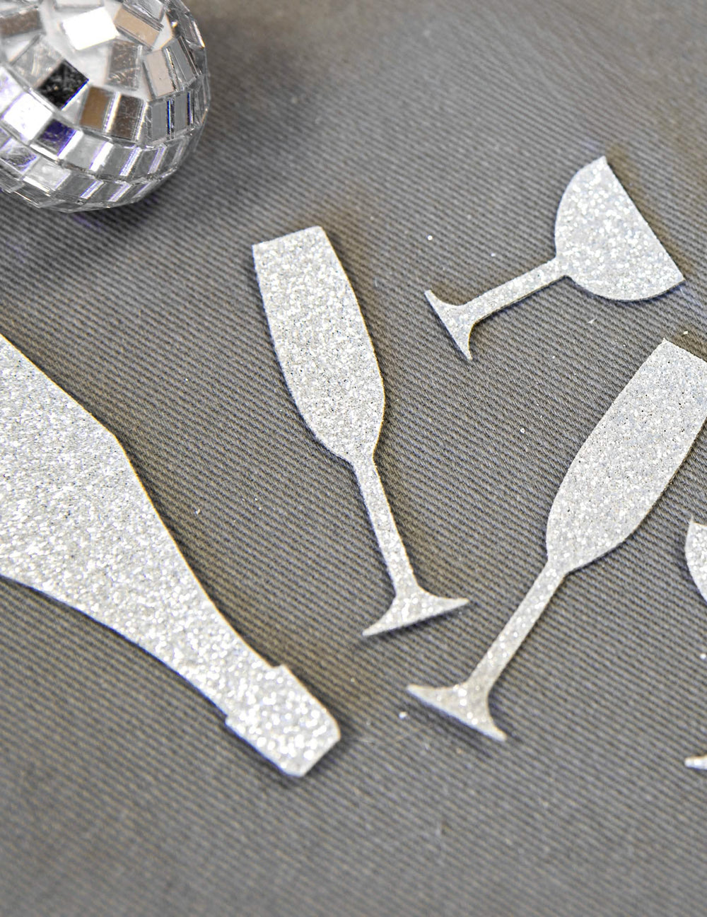 Grande plano sobre a textura brilhante dos confettis de mesa champanhe prateados, copos e flautas