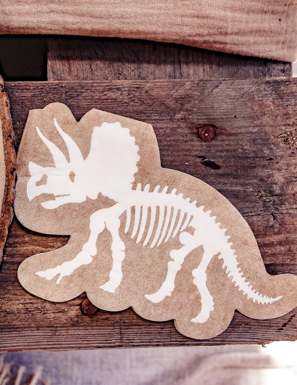 Détail du motif des serviettes dinosaures squelette tricératops