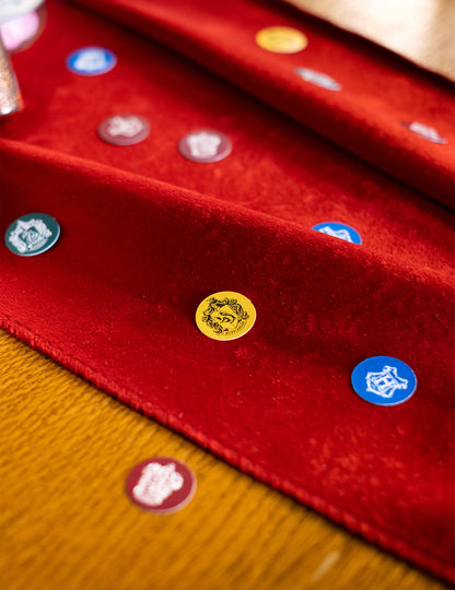 Détail des confettis Harry Potter dispersés sur un chemin de table rouge