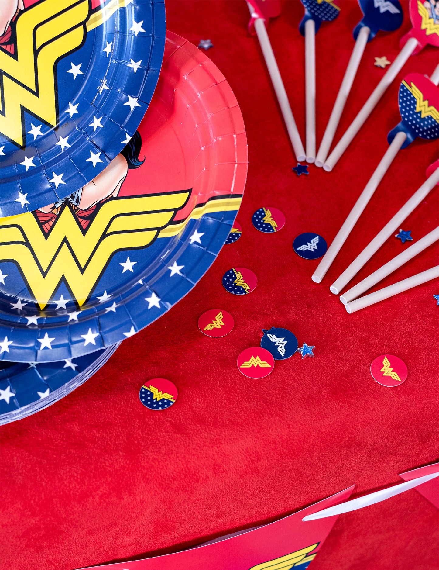 Mise en scène avec assiettes et pailles thématiques du confettis Wonder Woman