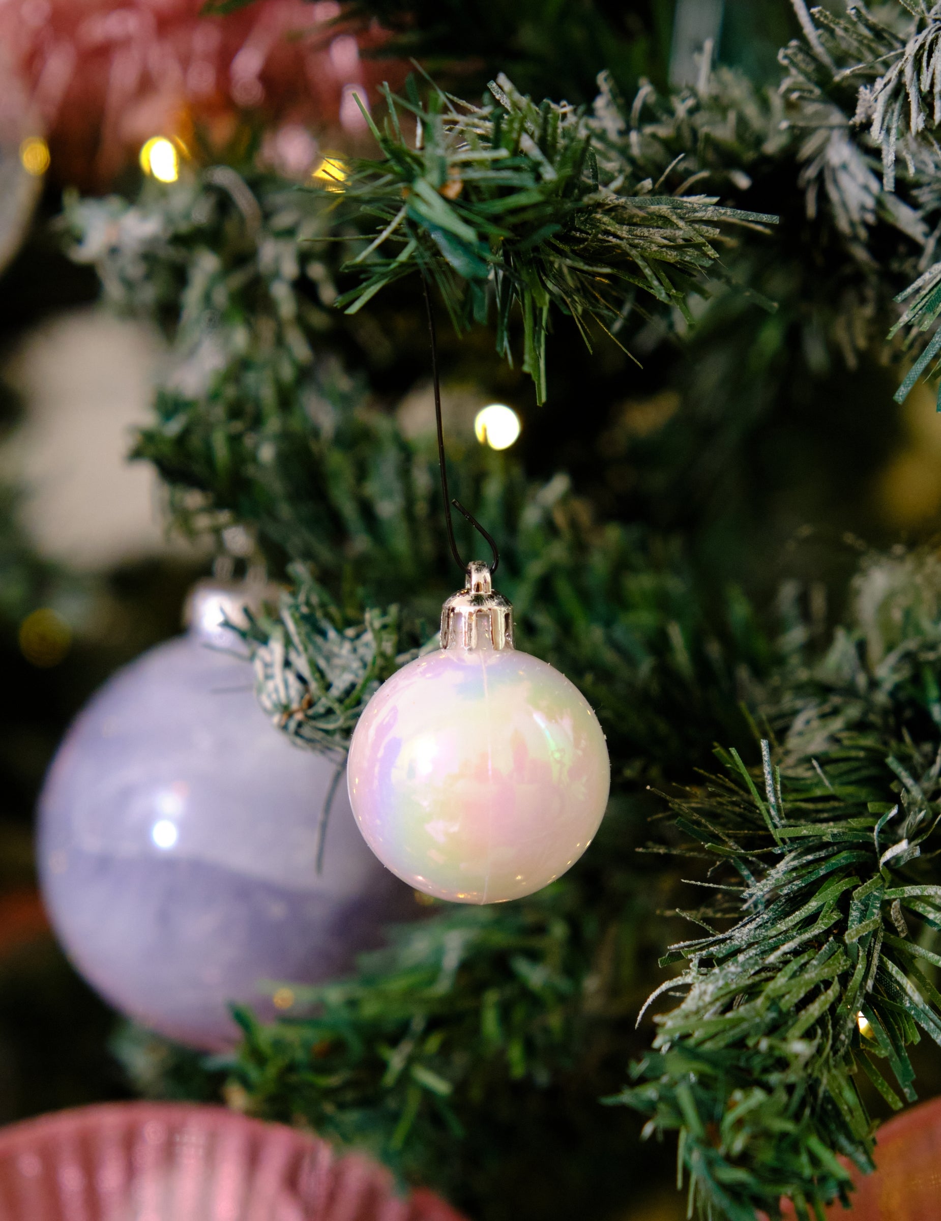 Mise en situation dans un sapin du lot de 18 mini boules de Noël blanches pailletées et mates