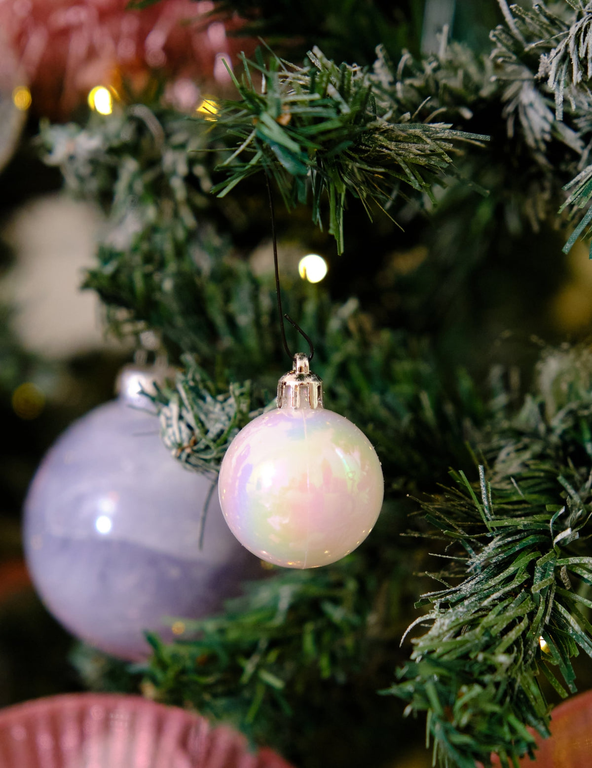 Mise en situation dans un sapin du lot de 18 mini boules de Noël blanches pailletées et mates