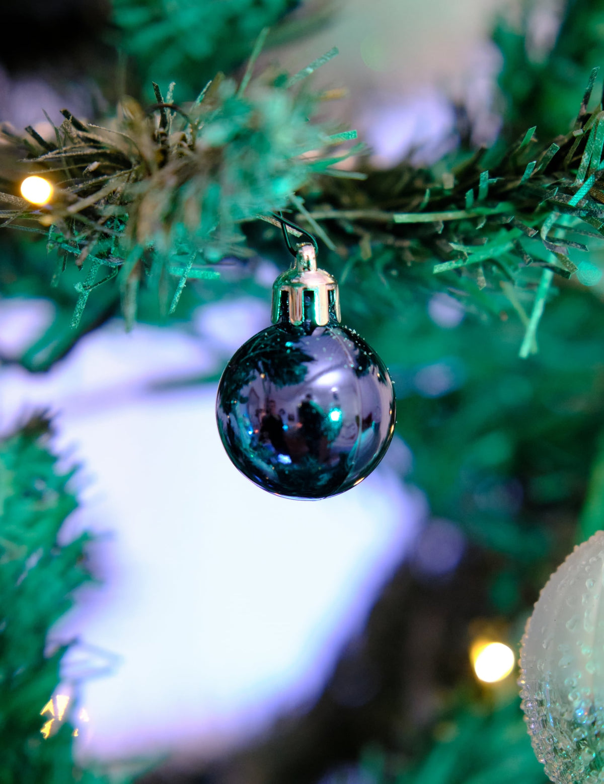 Gros plan sur une boule brillante suspendue des mini boules de noël bleu nuit mates et brillantes