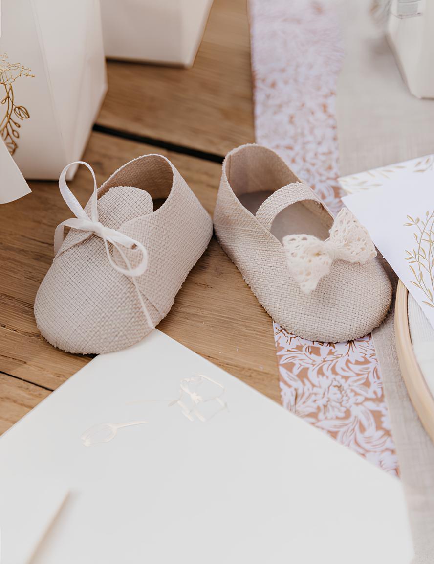 Détail des nœuds en ruban et dentelle des contenants en forme de chaussures bébé effet lin