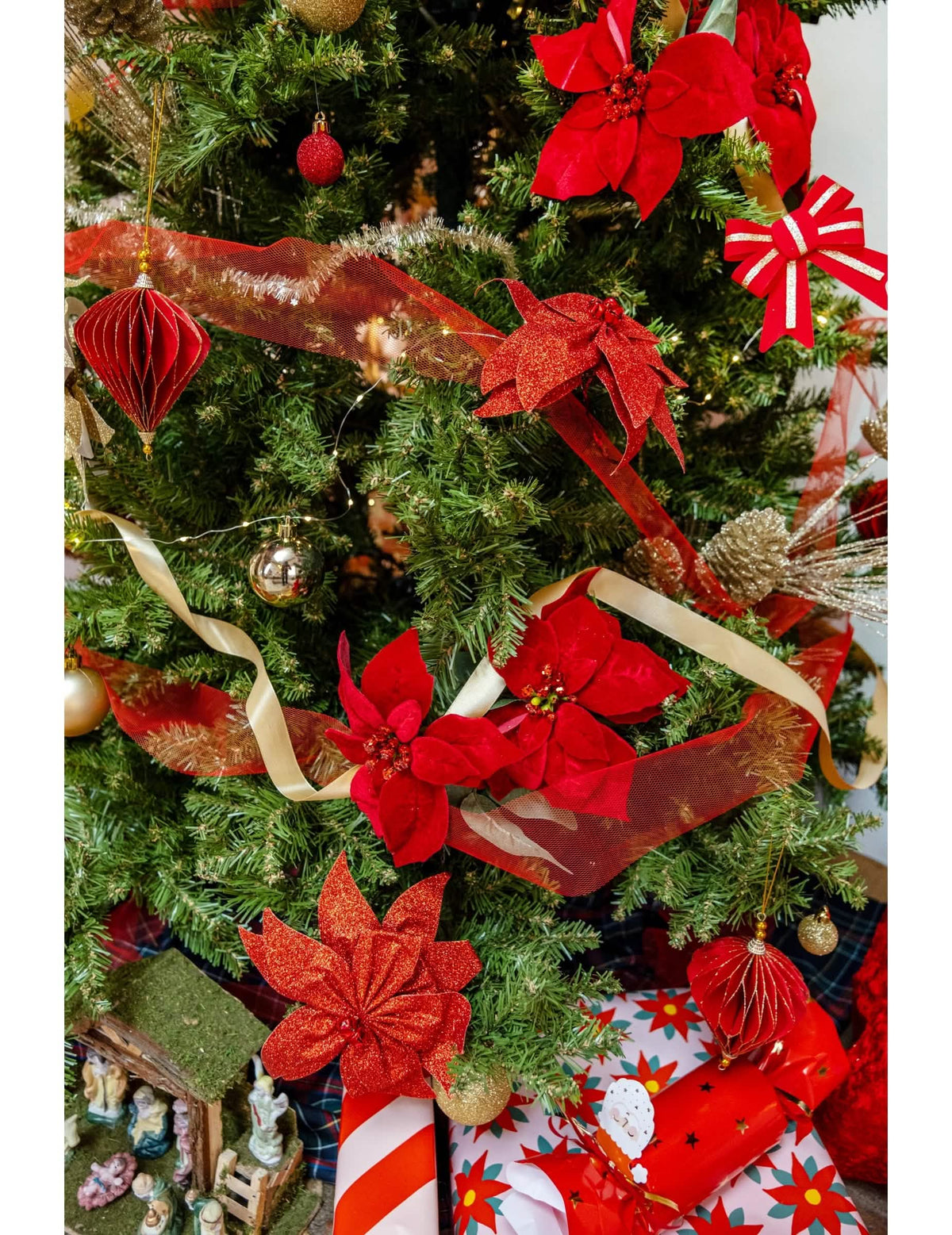 Cena num pinheiro de natal com suspensões origami em losangos vermelhos e dourados