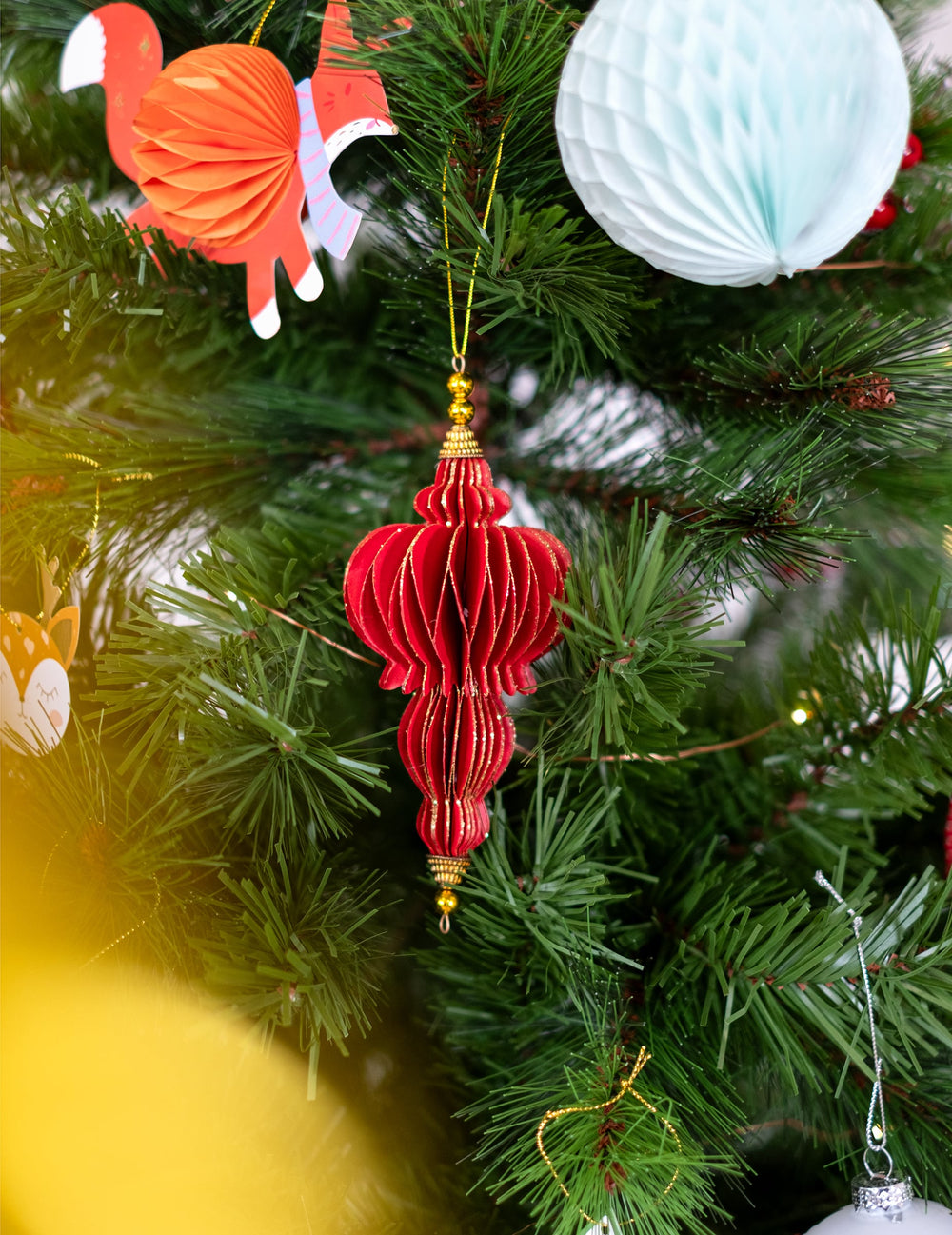 Mise en situation dans un sapin des suspensions origami pour fête rouges et dorées