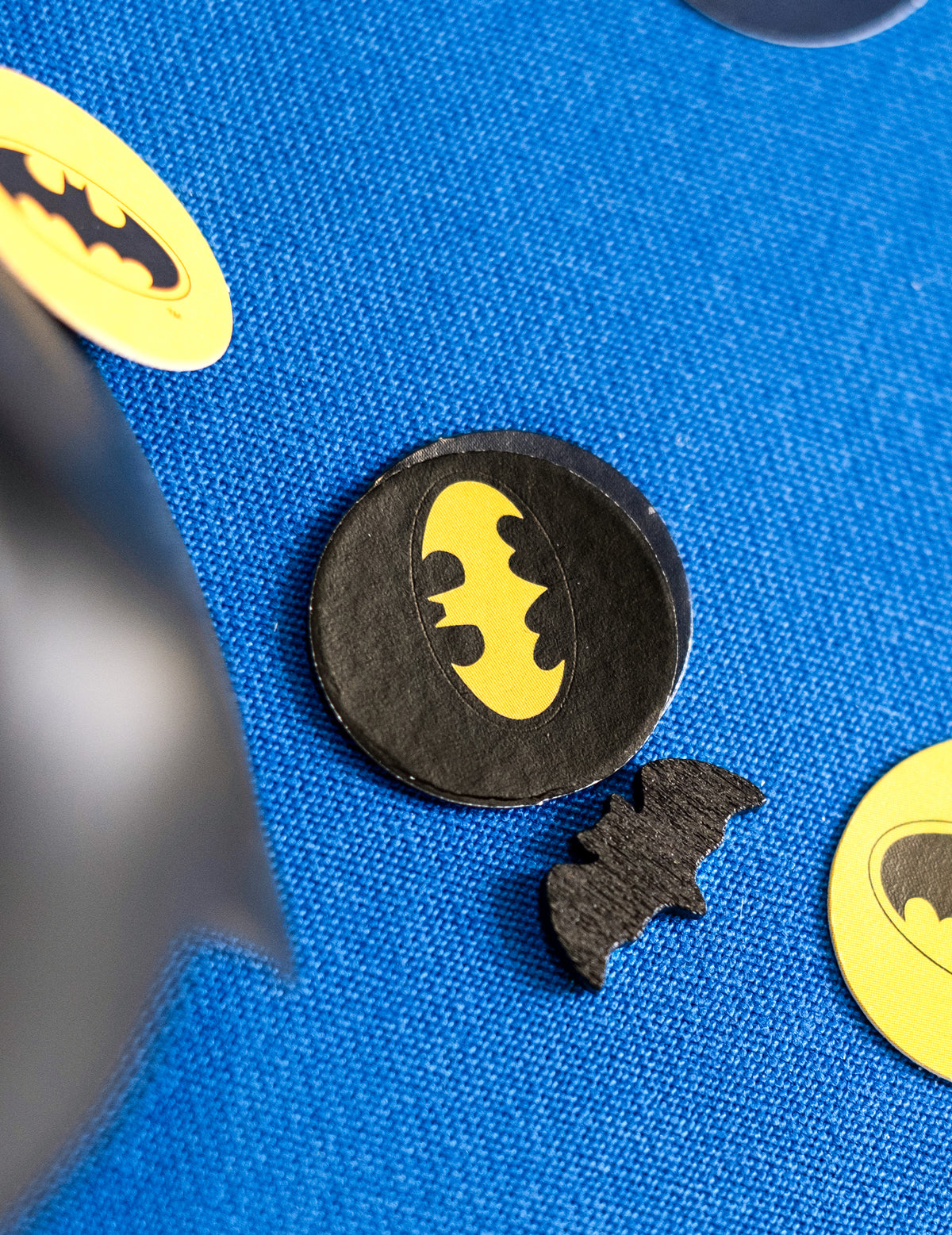 Gros plan sur les différents motifs des 20 confettis de table chauve-souris Halloween noir