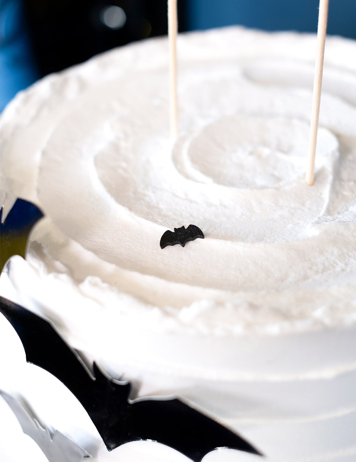 Détail d'un confetti posé sur un gâteau des 20 confettis de table chauve-souris Halloween noir