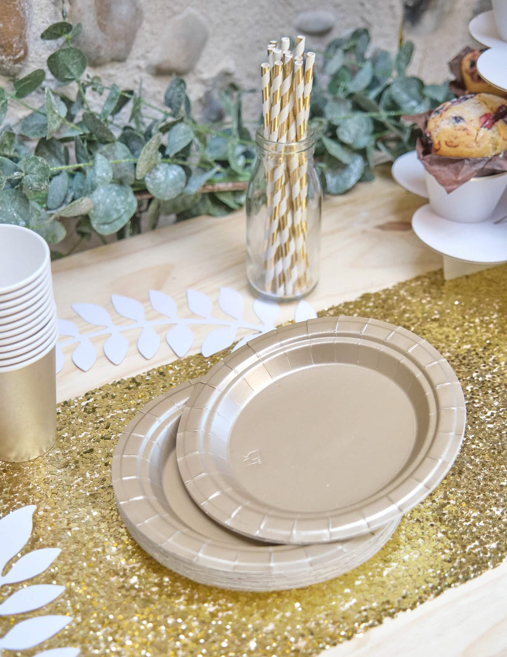 Encenação numa mesa de pequenos pratos de cartão para festa dourado mate
