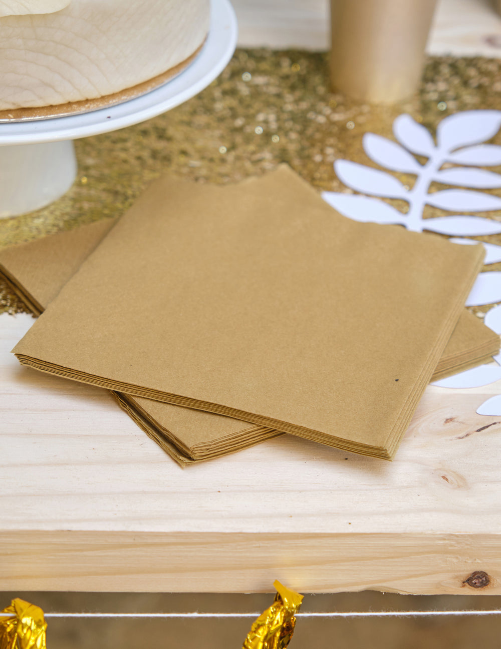 Mise en situation sur une table des 20 serviettes en papier festives dorées