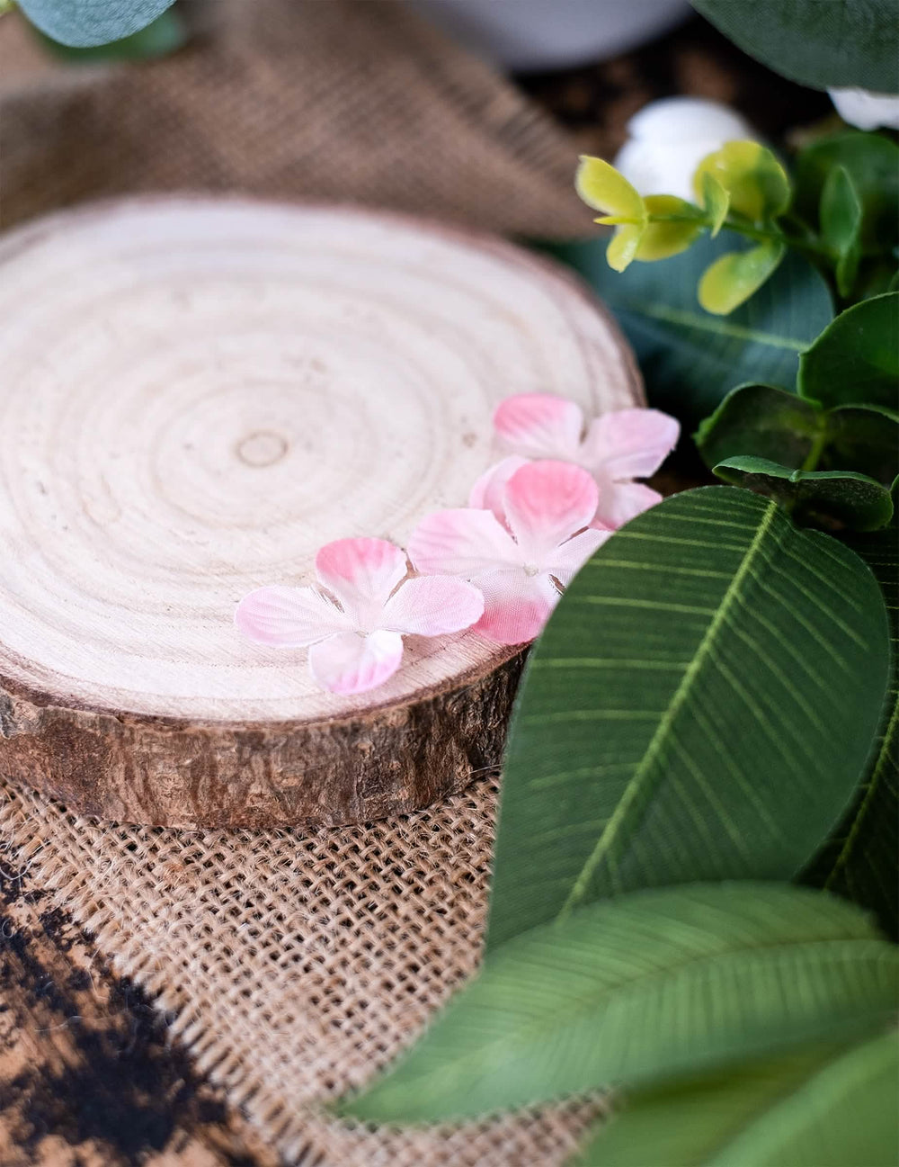 Detalhe sobre um tronco de madeira das decorações de mesa pétalas de flores para festa rosas artificiais