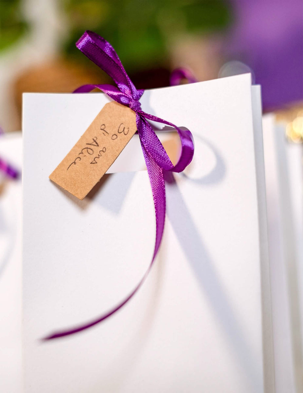 Detalhe da fita e da personalização das etiquetas perfuradas de casamento para festa