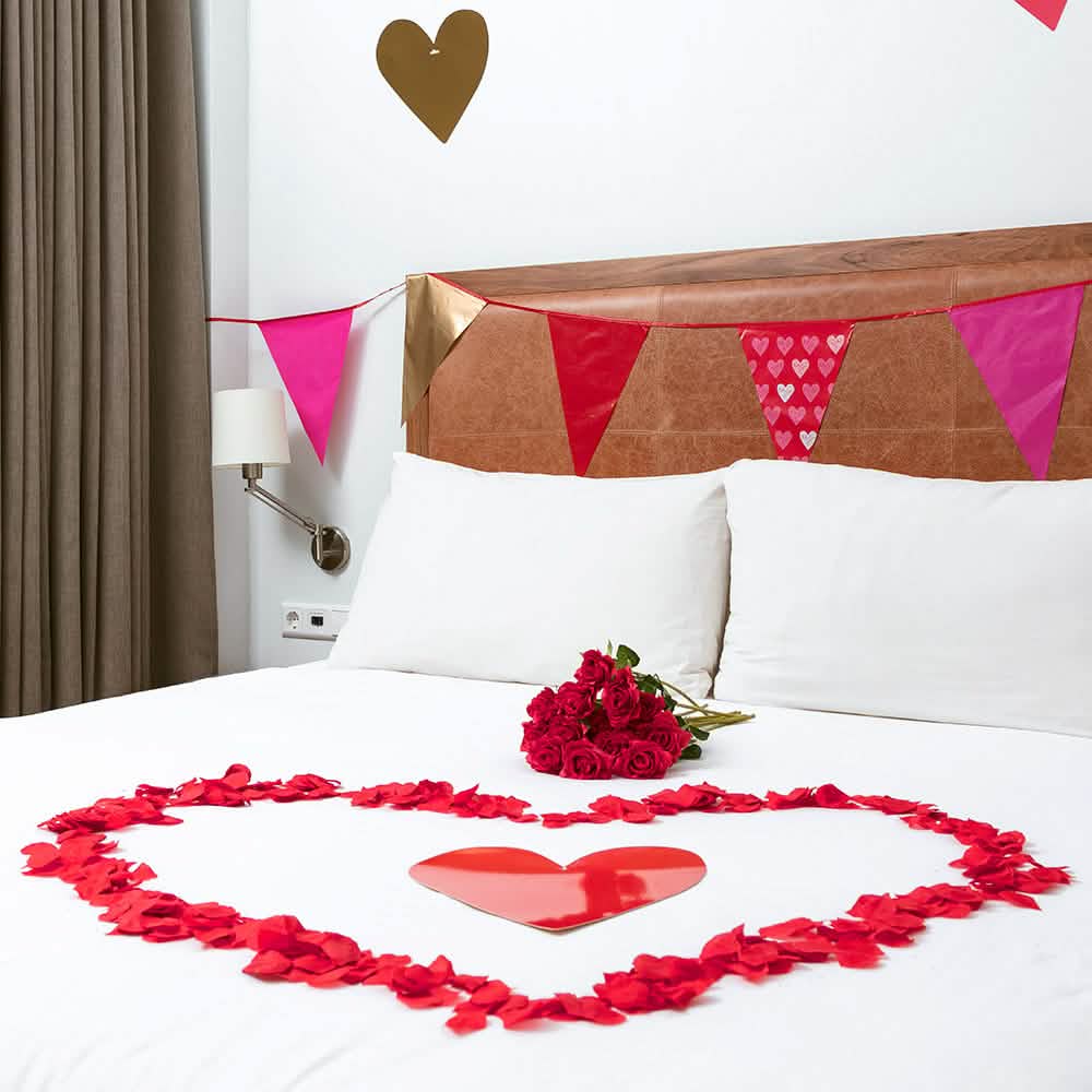 Coração formado sobre um leito de pétalas de cor de rosa para decoração de festa