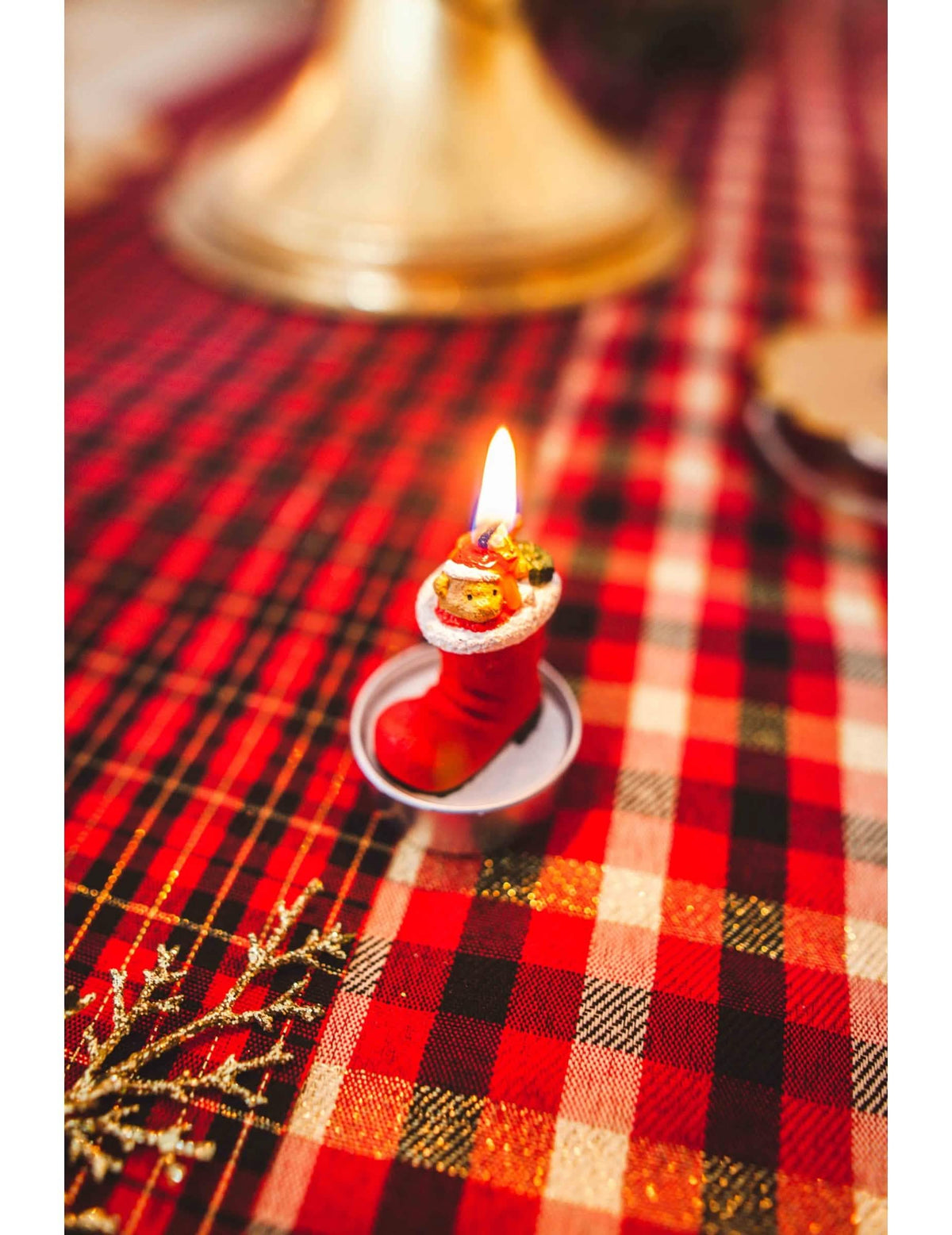 Zoom na vela acesa das 3 velas bota do pai natal com ursinho