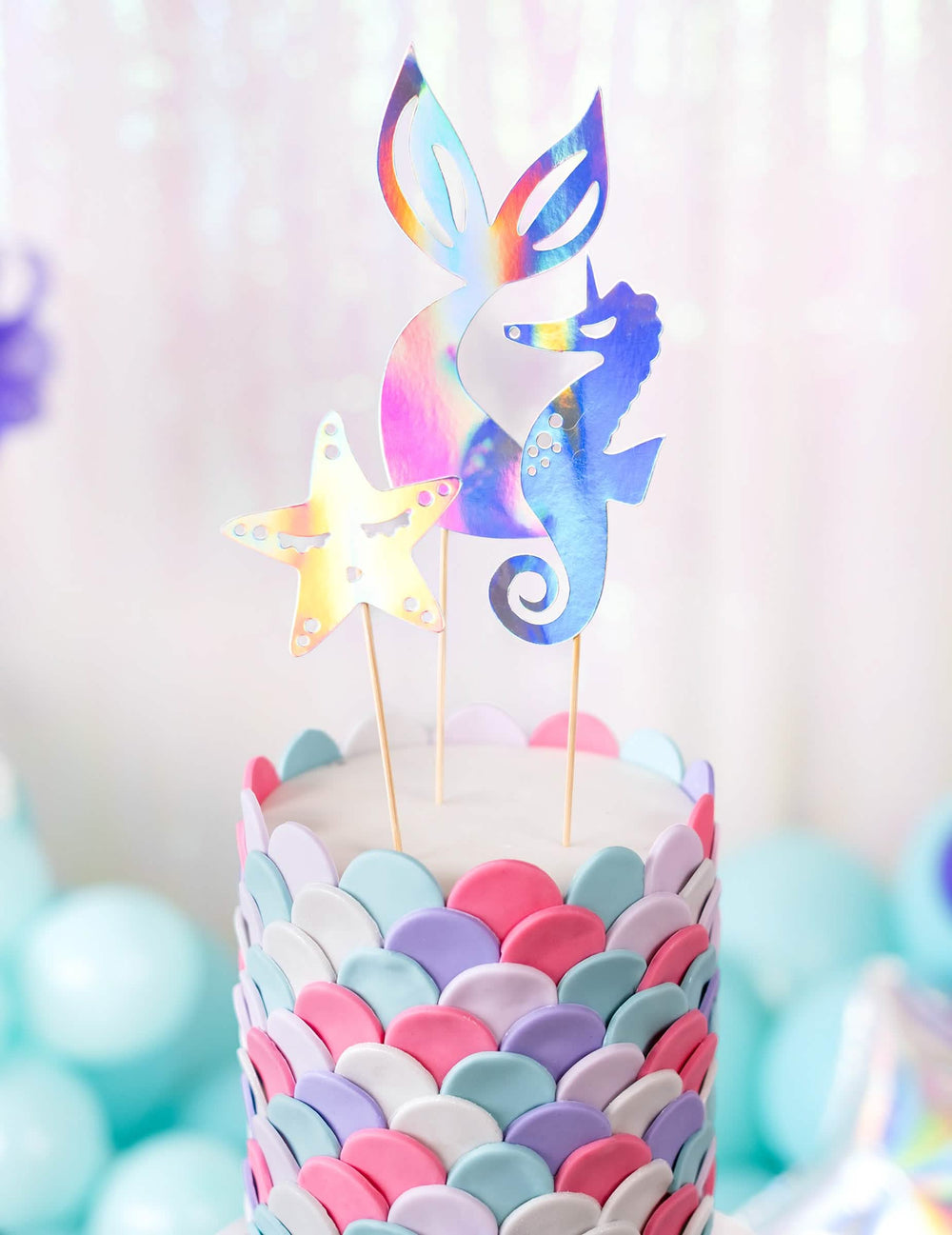 Grande plano na cauda, na estrela e no cavalo-marinho do cake toppers sereias