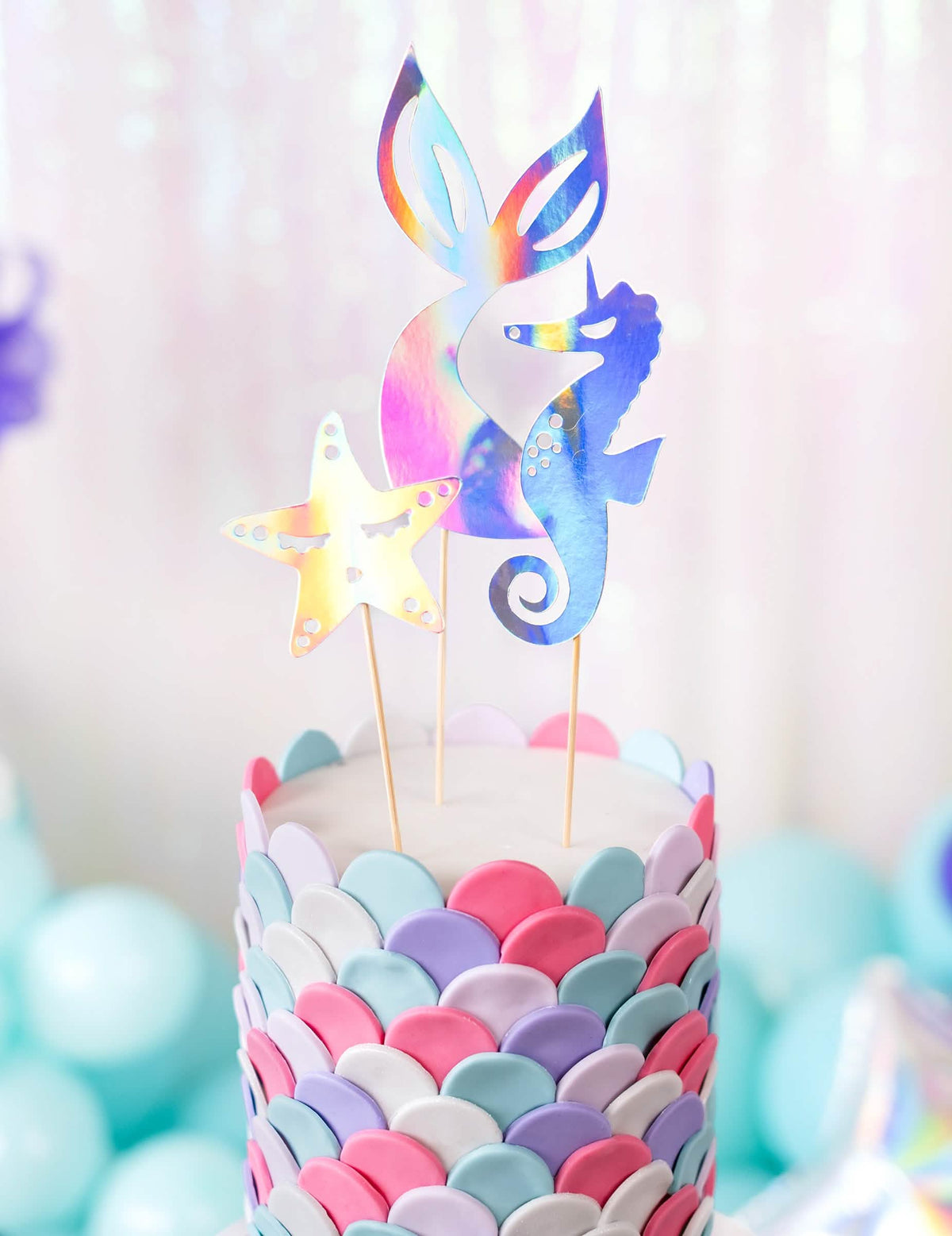 Grande plano na cauda, na estrela e no cavalo-marinho do cake toppers sereias