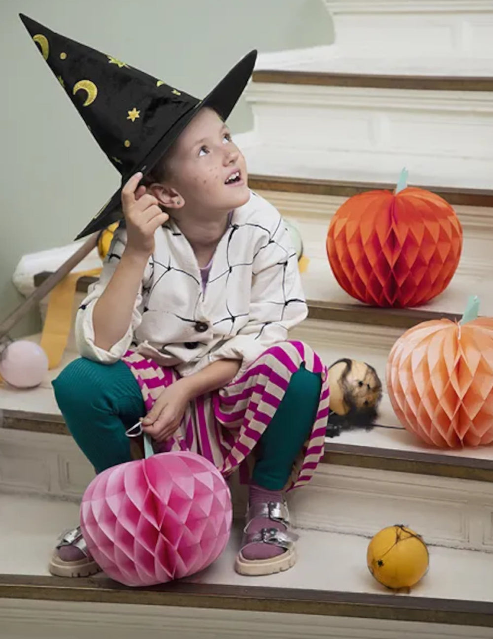 Mise en situation avec enfant des citrouilles en papier alvéolé Halloween pour décoration de fête