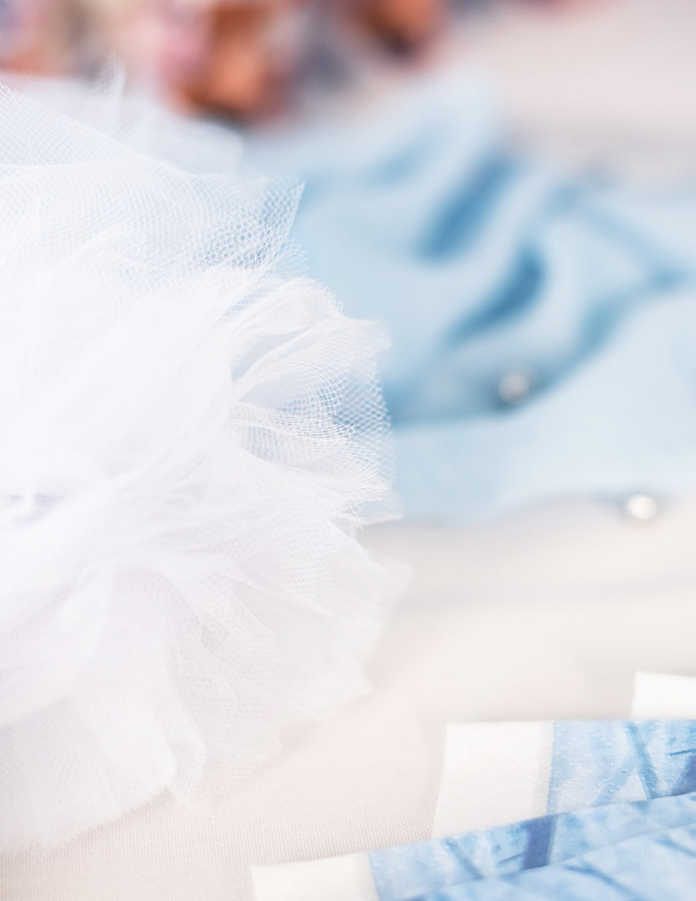 Gros plan sur la texture des pompons à suspendre en tulle pour décoration blancs
