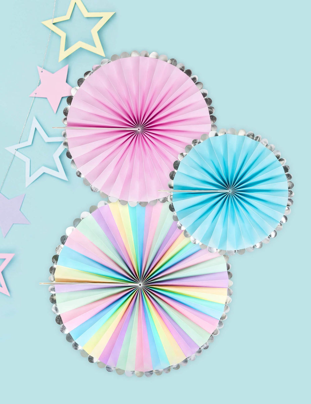 Vista de cima de rosetas decorativas pastel e prateadas para festa