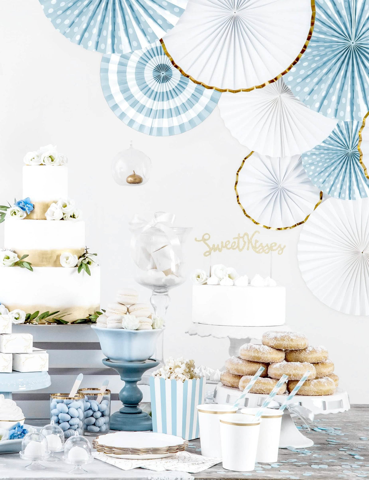 Encenação num buffet de festa de 3 rosetas de papel brancas e douradas para decoração