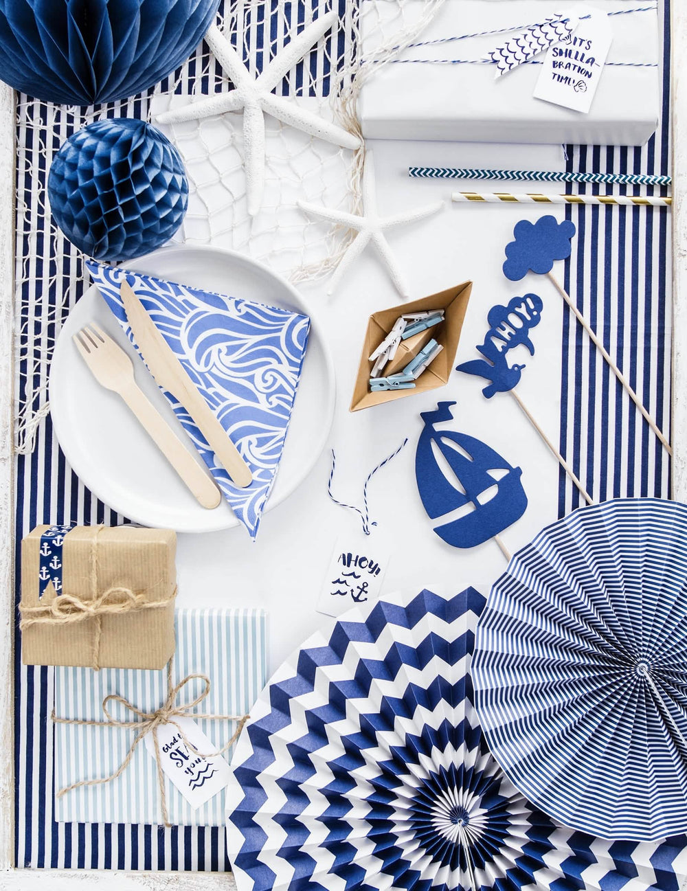 Mise em situação sobre uma mesa de festa de 3 rosáceas em papel azul-marinho com padrões