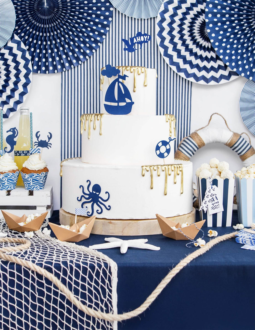 Composição de buffet marítimo com 3 rosetas em papel azul com padrões