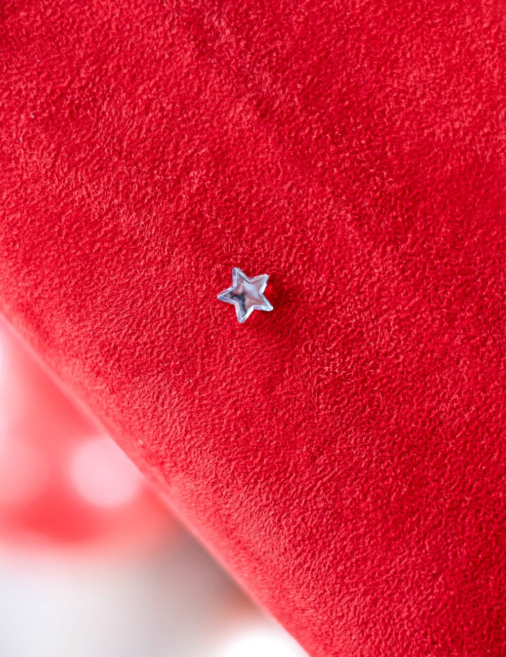 Grande plano de uma estrela sobre fundo vermelho dos confettis de mesa estrelas espelho para festa