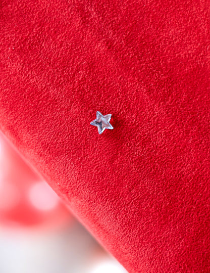 Gros plan d'une étoile sur fond rouge du confettis de table étoiles miroir pour fête