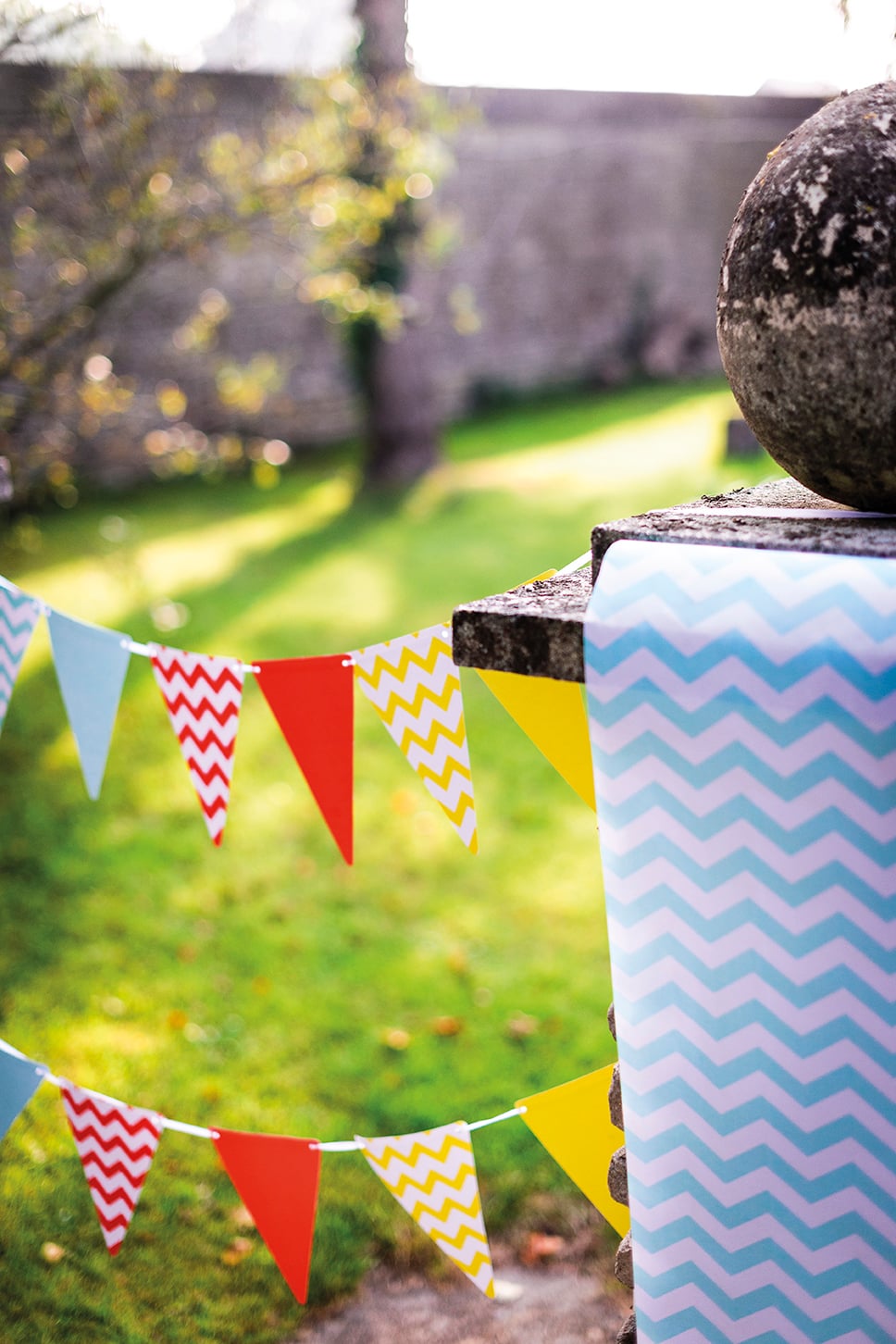 Mise en situation dans un jardin du fanion diy turquoise en carton