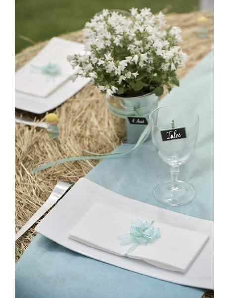 Colocação numa toalha de mesa de mini laços decorativos em organza turquesa