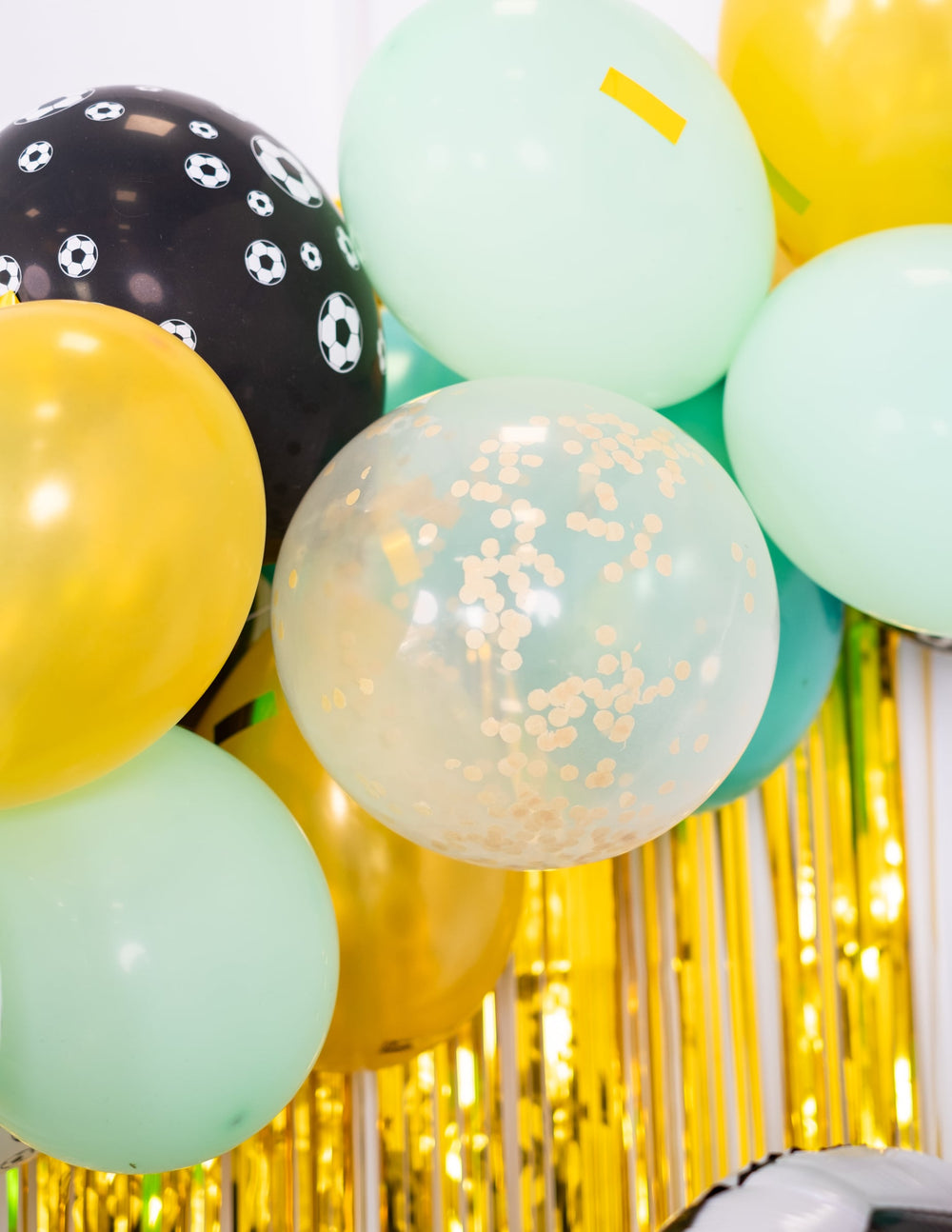 Zoom sur la composition des ballons en latex avec confettis transparents ocre doré