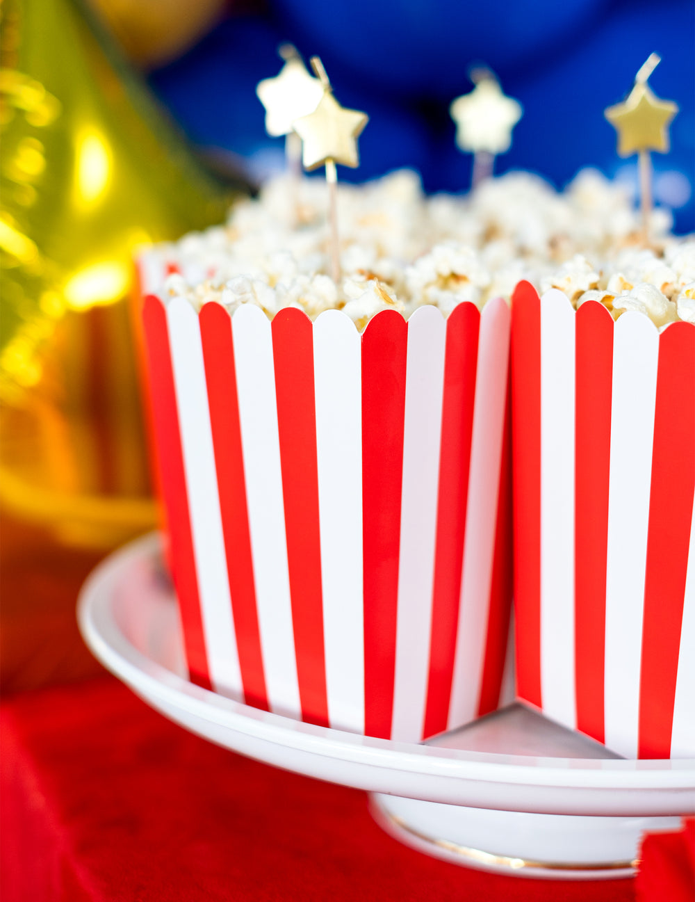 Gros plan sur le contenu avec pics étoiles des boîtes à popcorn en carton pour fête rouges et blanches à rayures