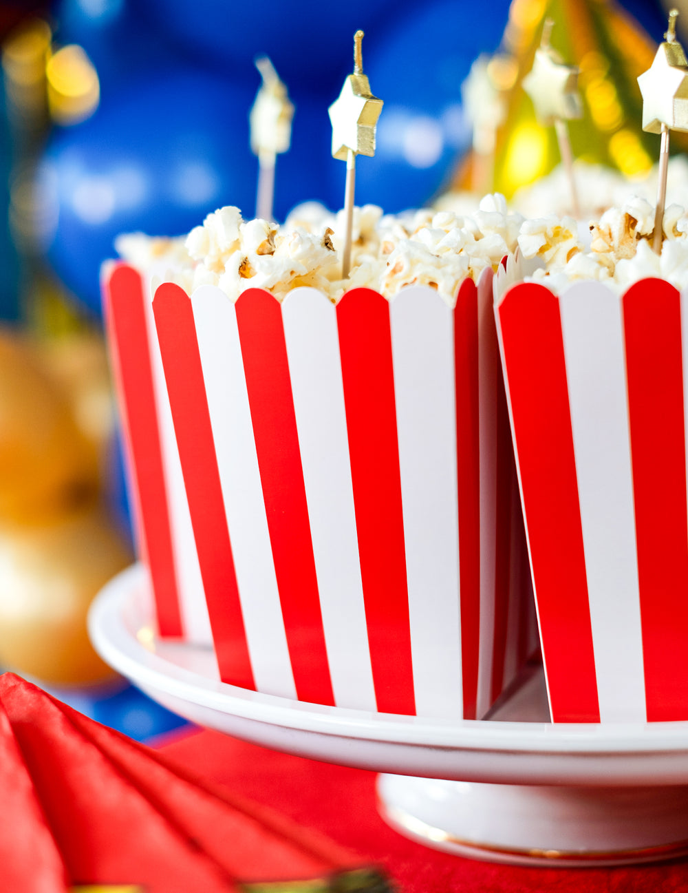 Gros plan sur le popcorn et les pics dorés des boîtes à popcorn en carton rouges et blanches
