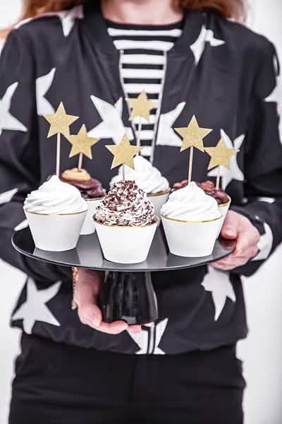 Encenação com cupcakes, toppers de estrelas para bolos douradas e com brilhantes