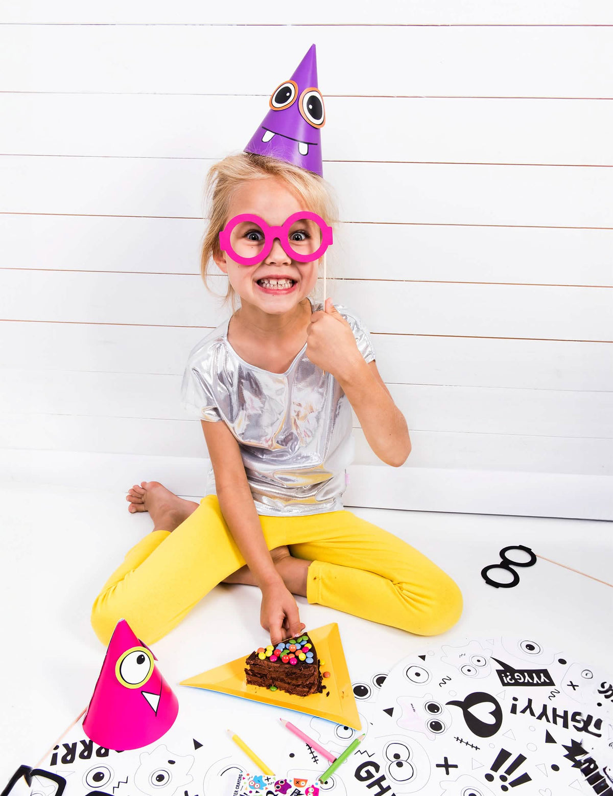 criança a usar o chapéu roxo do chapéus de festa pequenos monstros