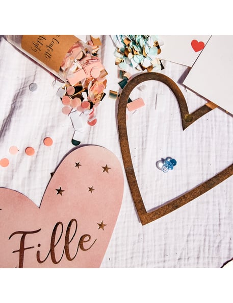 Détail du coeur rose et des confettis des décorations de table fille ou garçon pour gender reveal