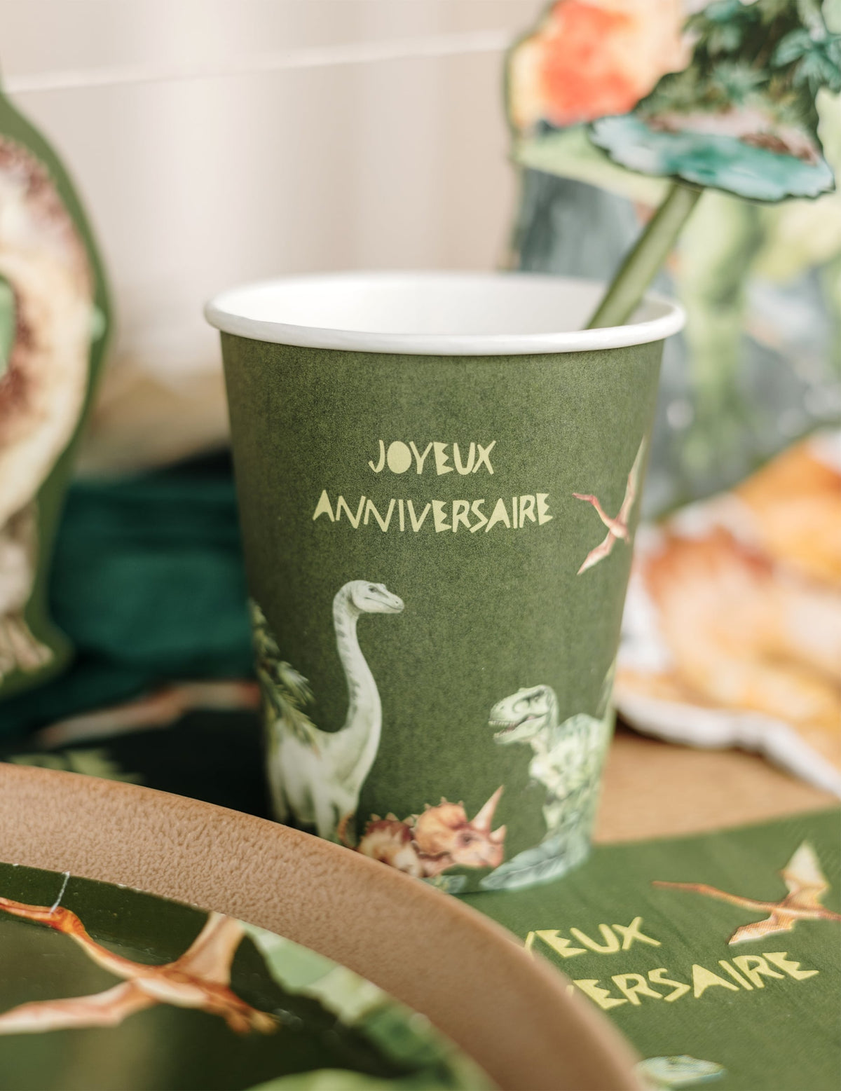 Gros plan sur les illustrations du gobelet joyeux anniversaire dinosaures