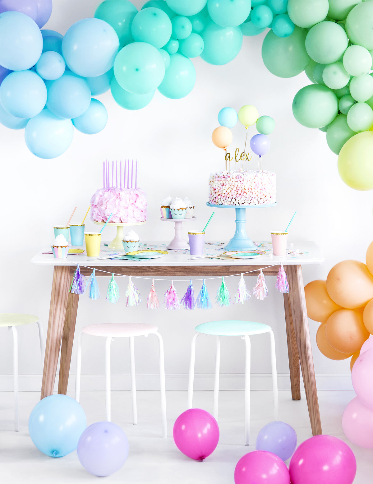 Mise en scène avec arche de ballons des habillages à cupcake licorne pastel