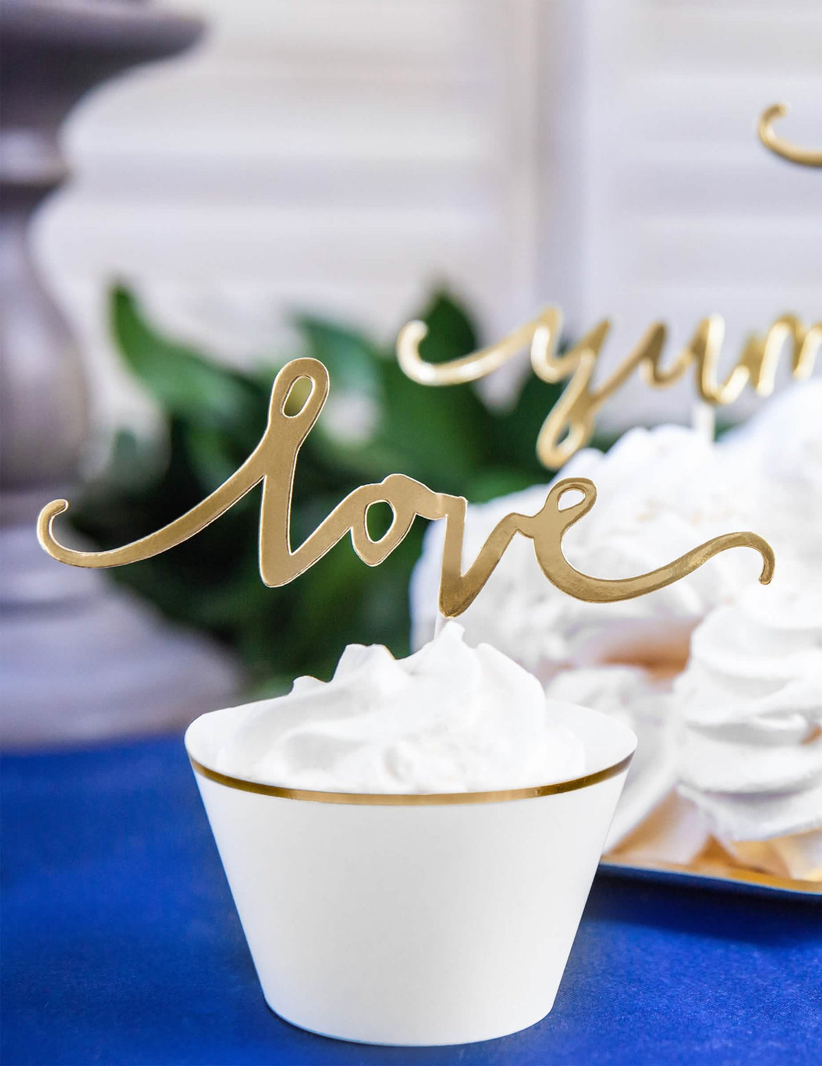 Close-up no cake topper love dourado dos habillages para cupcakes em papel para casamento