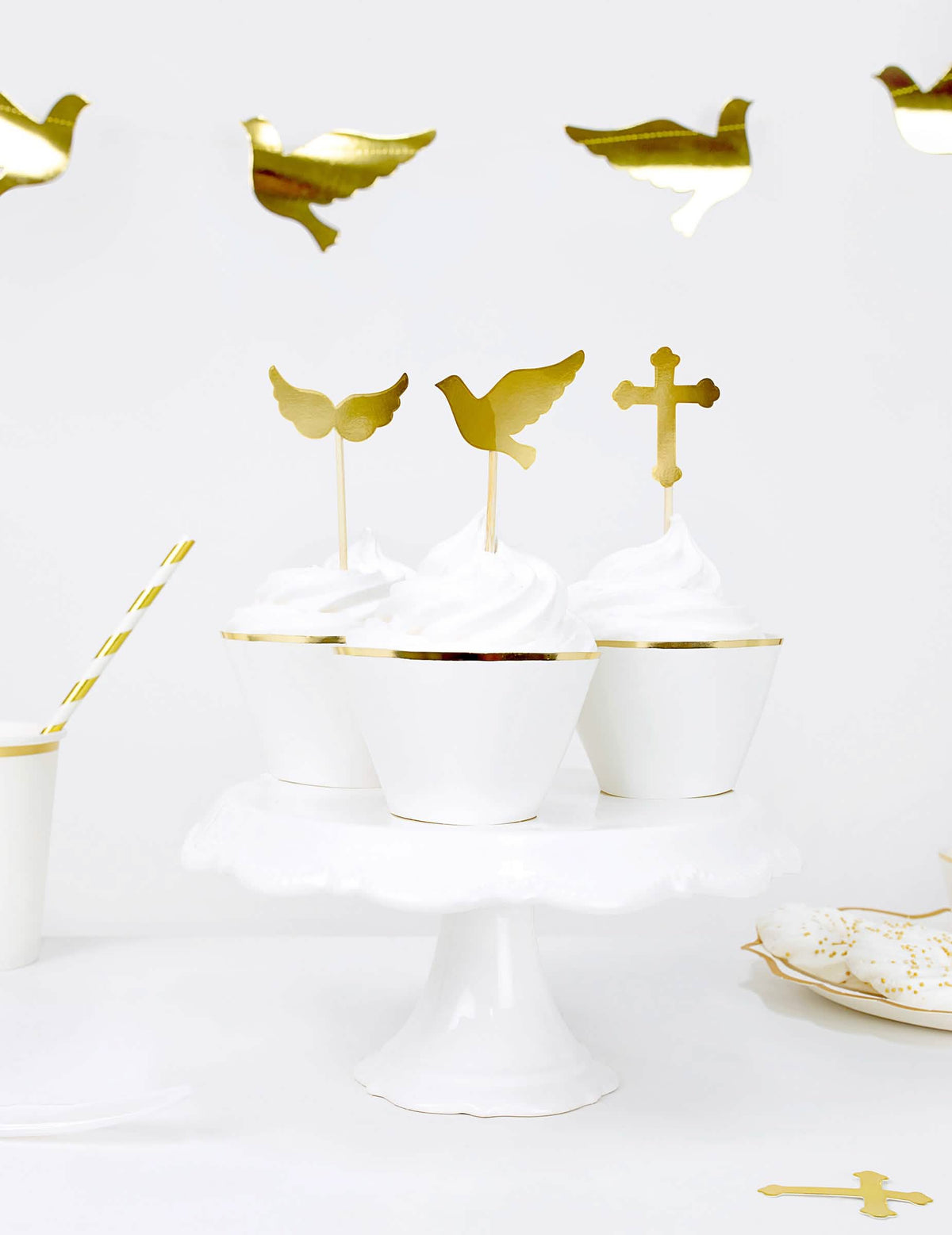Vista dos cupcakes com toppers pombas e cruzes dos adornos para cupcakes em papel para casamento