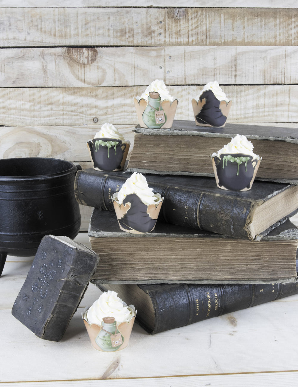 Mise en scène sur des livres anciens des habillages moules à cupcake apprenti sorcier