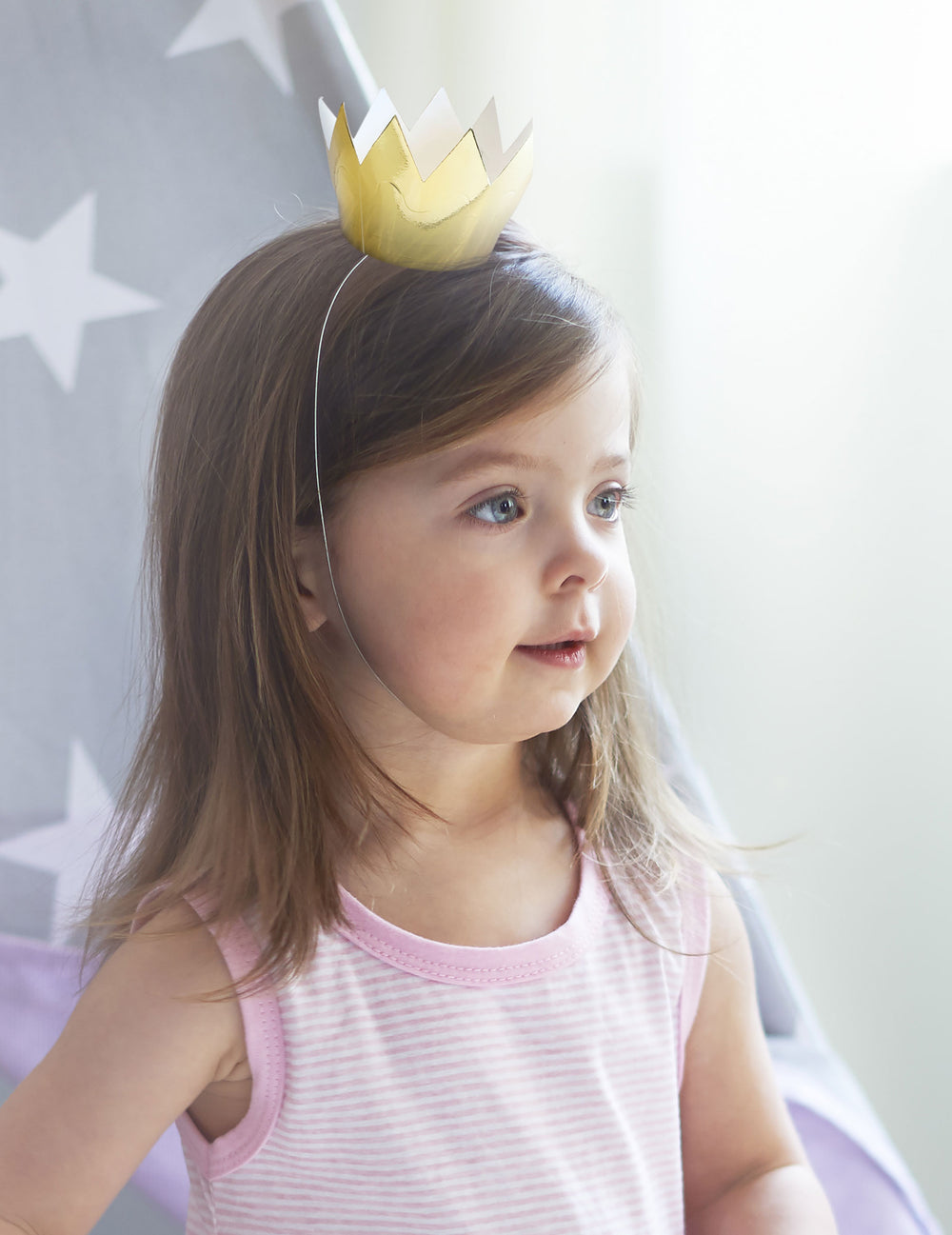 Vue portée par un enfant des 6 mini couronnes dorées pour fête en carton brillant