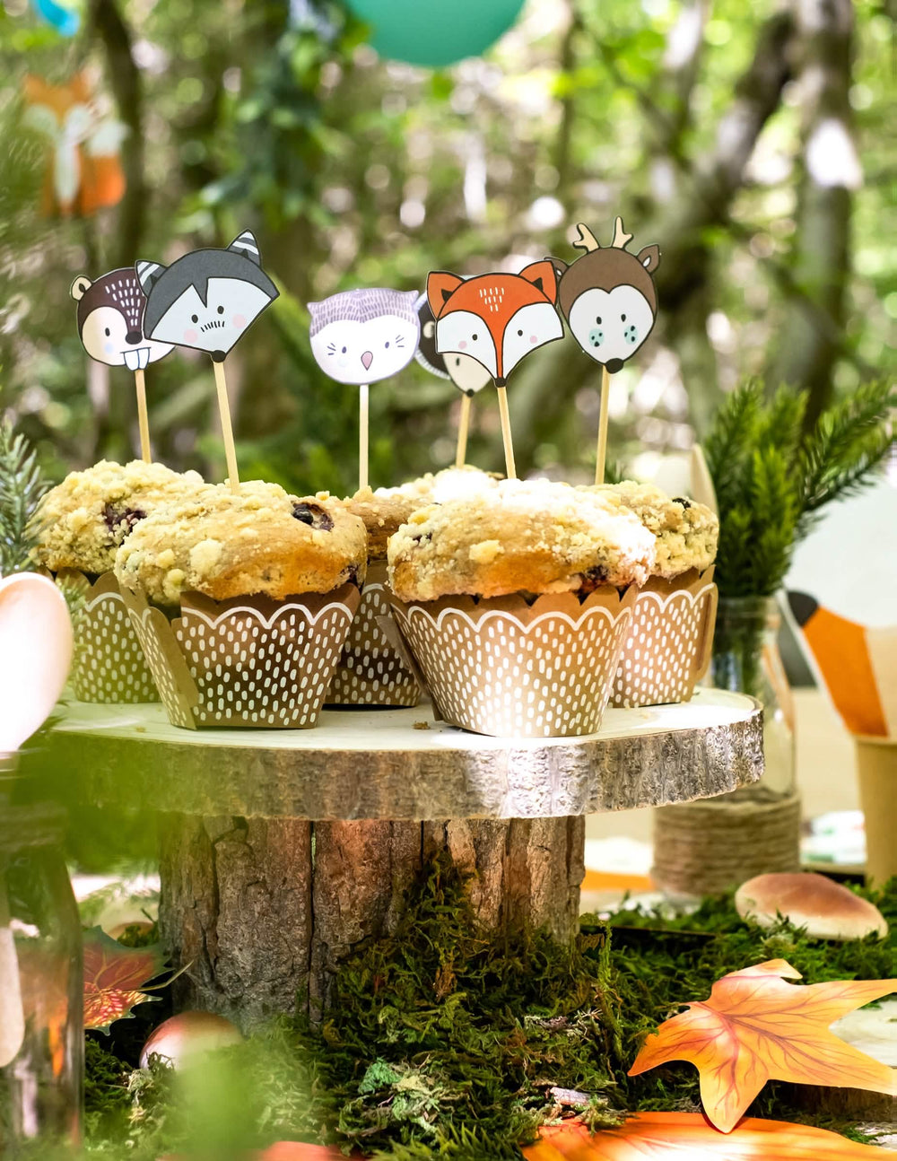 Grande plano dos muffins decorados com as formas de cupcake e espetos de madeira animais da floresta