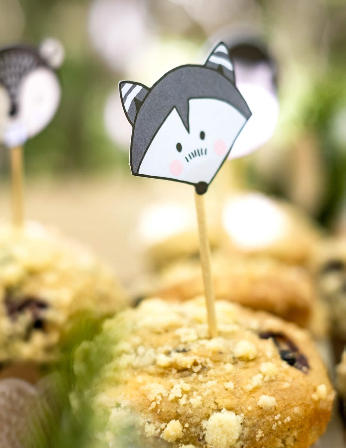 Grande aproximação do palito de madeira com guaxinim dos moldes para cupcake e palitos de madeira animais da floresta