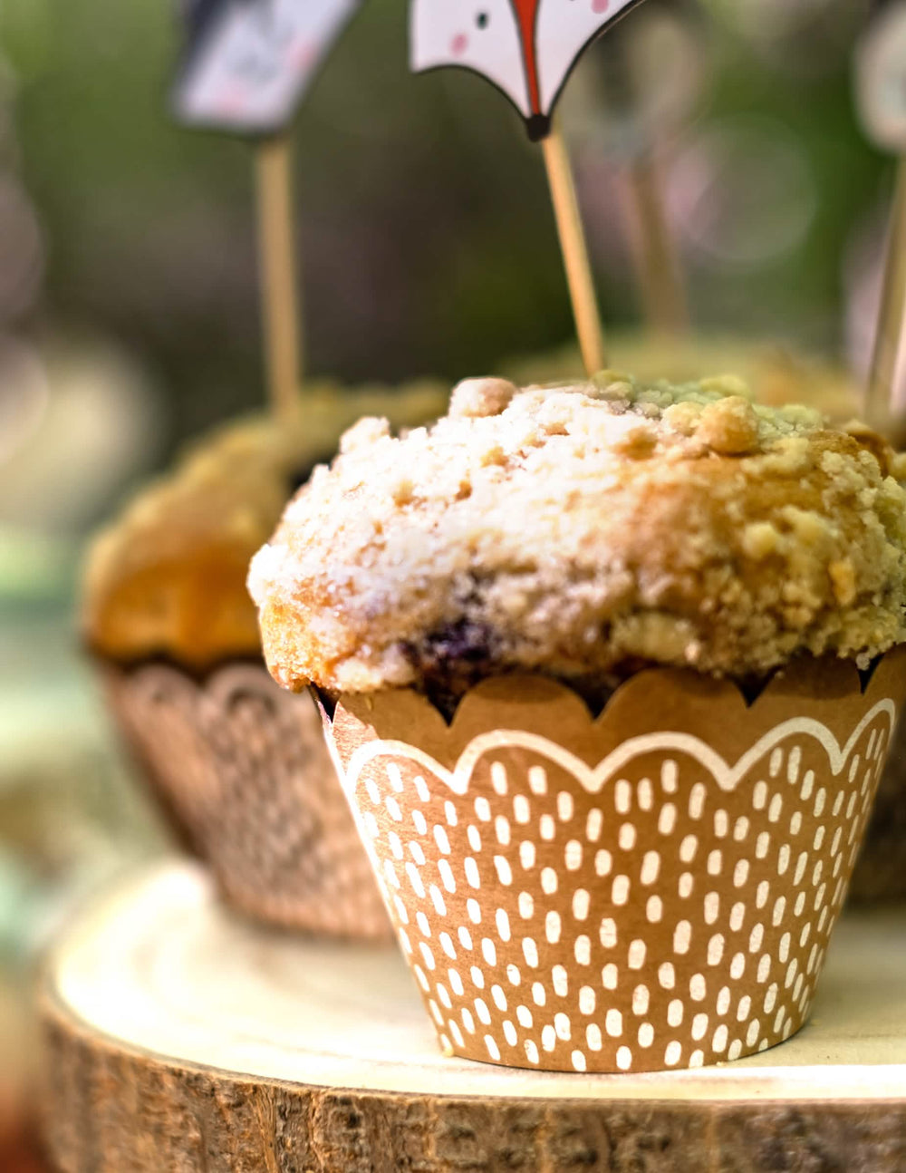 Grande plano sobre o padrão kraft das formas de cupcake e dos palitos de madeira com animal da floresta