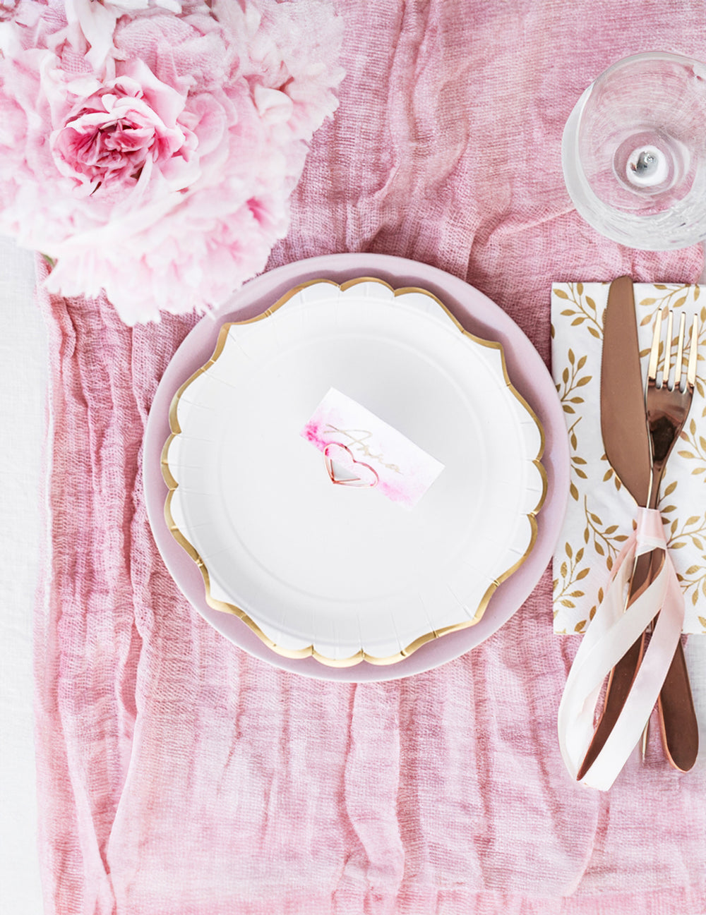 Vue de dessus des petites assiettes en carton bordures ciselées pour fête blanches et dorées