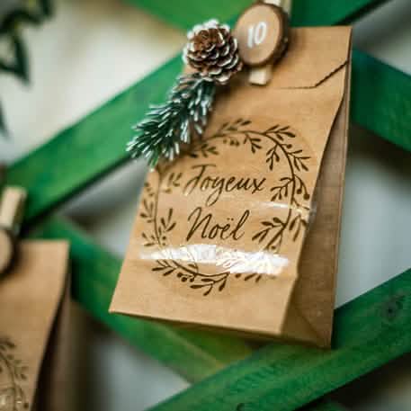 Grande plano do saco natal dos pequenos sacos kraft castanho para convidados com etiquetas e cordões brancos