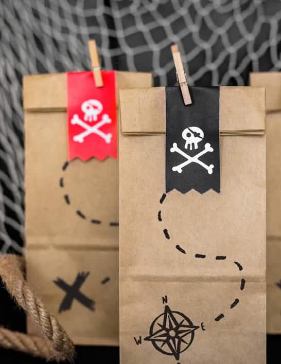 Detalhe das etiquetas de caveira e pinças de madeira dos sacos de prenda pirata para criança